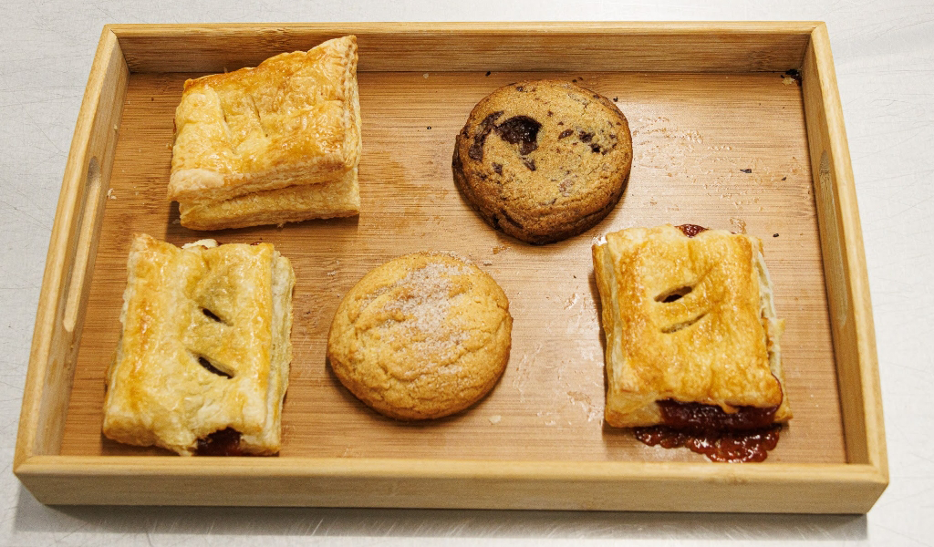 Platter with several Cuban pastries, including two cookies and three filled croissants